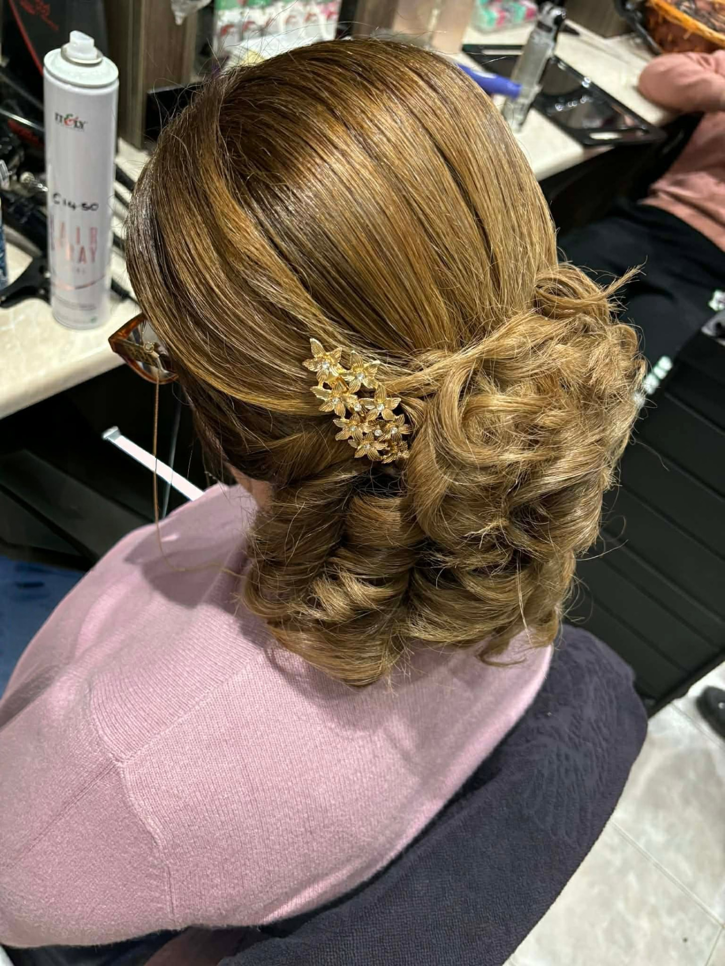 Elegant low bun updo with gold floral hairpiece