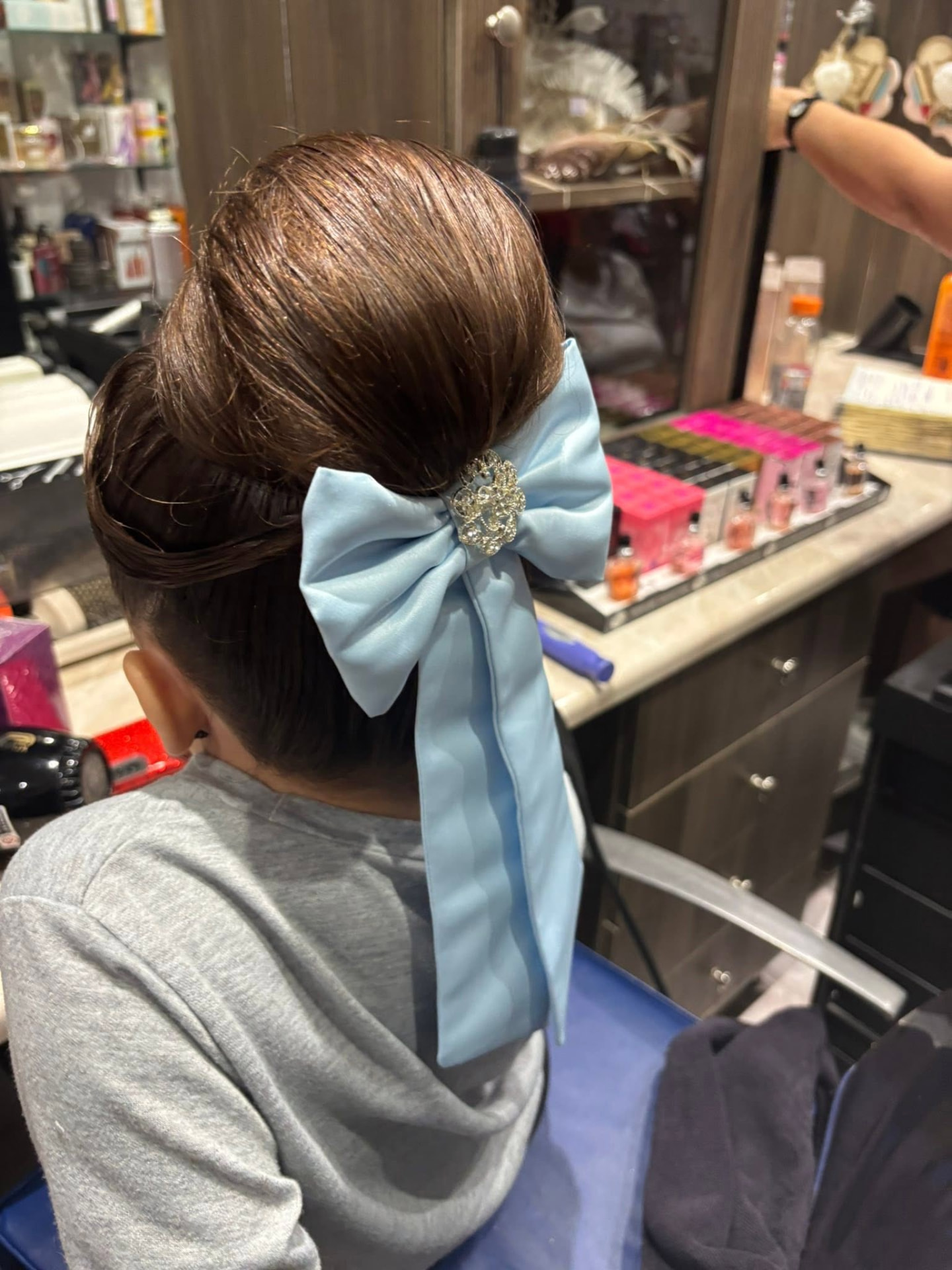 Classic high bun updo with light blue satin ribbon bow