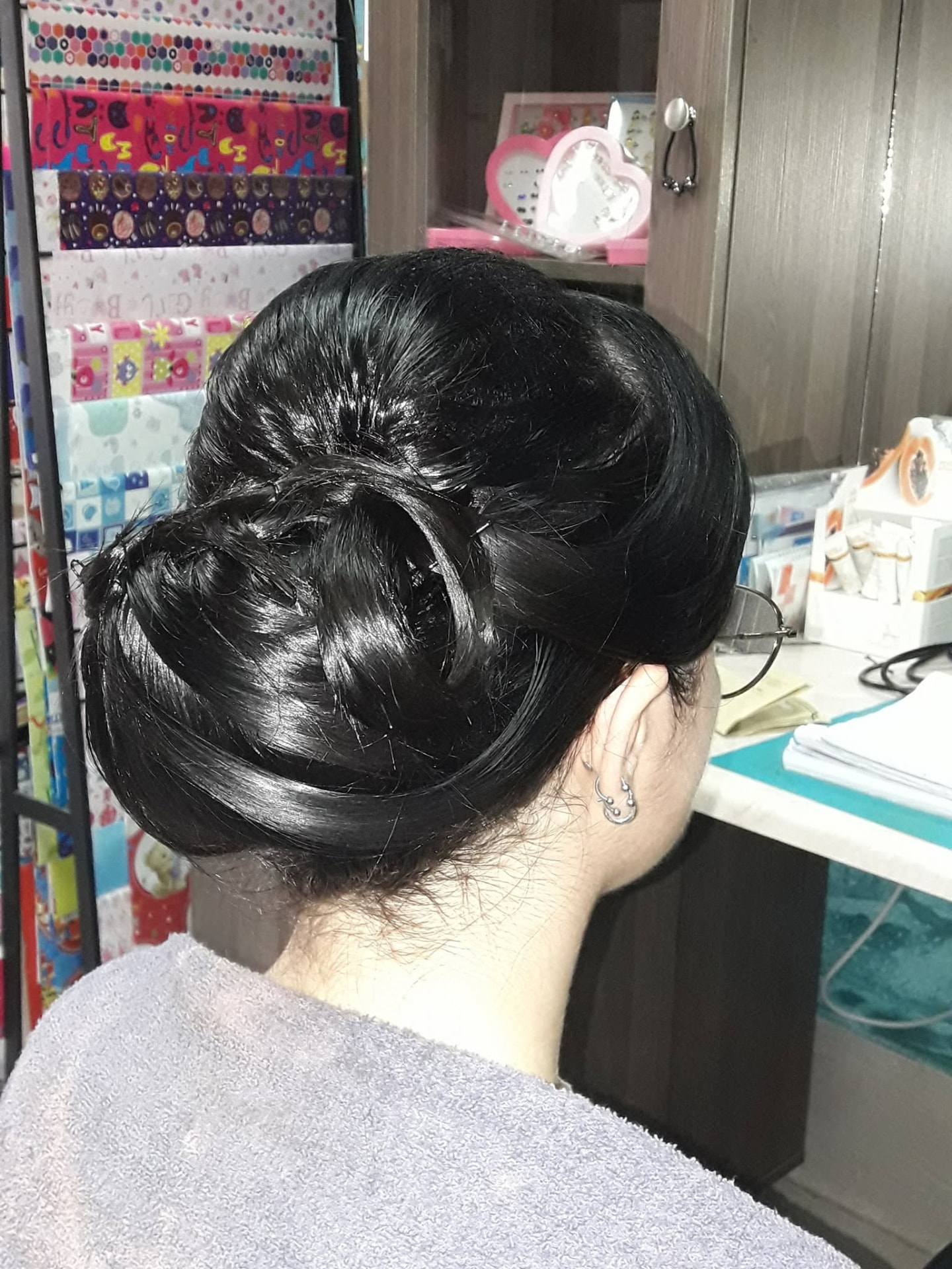 Glossy jet black twisted bun haircut and styling